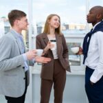 man in white long sleeve shirt standing beside woman in brown blazer